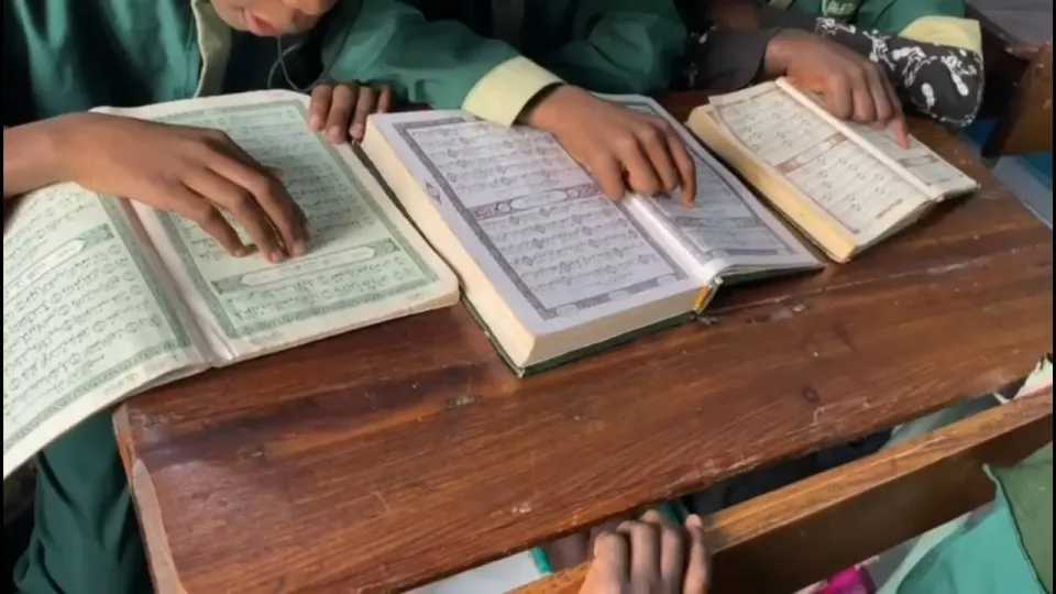 Vidéo de l'école : cours au tableau, façade, vue aérienne, couloirs et élèves lisant le Coran